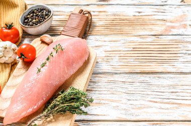 Kesme tahtasında çiğ hindi göğsü. Biftek. Beyaz ahşap arka plan. Üst Manzara. Boşluğu kopyala.