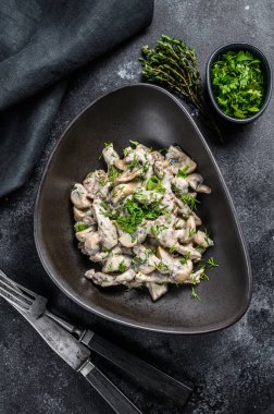 Mantarlı biftek ve taze maydanoz tabakta. Siyah arka plan. Üst görünüm.