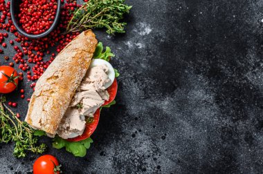 Ciabatta sandviçi, ciğer ezmesi, roka, domates, yumurta ve bitki. Siyah arka plan. Üst Manzara. Boşluğu kopyala.