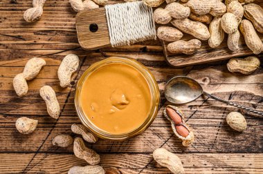 Cam kavanozdaki taze kremalı fıstık ezmesi. Ahşap arka plan. Üst görünüm.