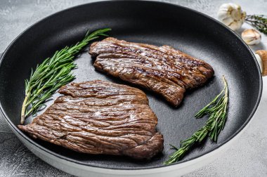 Kızarmış demir ve kanatlı biftekler. Mermer sığır eti. Gri arka plan. Üst görünüm.