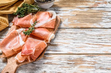 Kesme tahtasında İspanyol jamonu, jambon. Beyaz ahşap arka plan. Üst Manzara. Boşluğu kopyala.