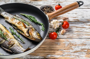 BBQ deniz levreği, tavada kızarmış levrek. Beyaz ahşap arka plan. Üst Manzara. Boşluğu kopyala.