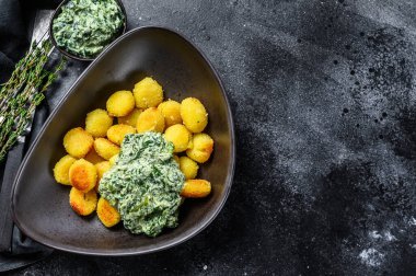 Kızarmış gnocchi patates makarna ve ıspanak. Siyah arka plan. Üst Manzara. Boşluğu kopyala.