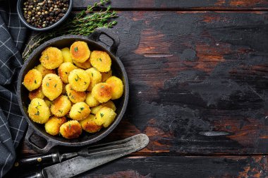 Tavada kızarmış ev yapımı patates Gnocchi. Siyah ahşap arka plan. Üst Manzara. Boşluğu kopyala.