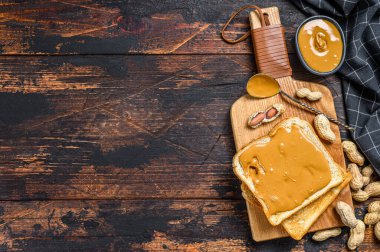 Kahvaltıda fıstık ezmeli çıtır tost. Karanlık ahşap arka plan. Üst Manzara. Boşluğu kopyala.