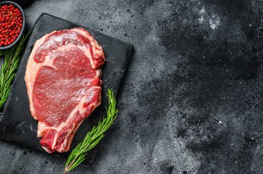 Çiğ kovboy bifteği. Kemik pirzolasında mermer et. Siyah arka plan. Üst Manzara. Boşluğu kopyala.