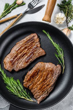 Kızarmış demir ve kanatlı biftekler. Mermer sığır eti. Gri arka plan. Üst görünüm.