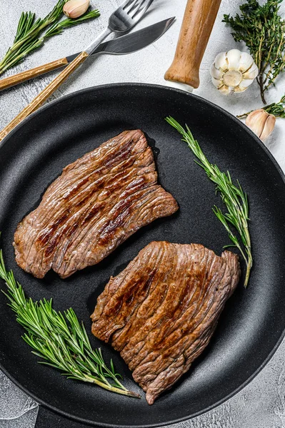 Kızarmış demir ve kanatlı biftekler. Mermer sığır eti. Gri arka plan. Üst görünüm.