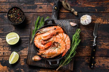 Kırmızı Kaplan karidesleri tavada. Koyu ahşap arka plan. Üst görünüm.