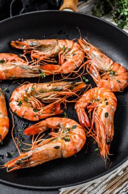 Tavada baharatlı ve limonlu ızgara karides. Beyaz ahşap arka plan. Üst görünüm.