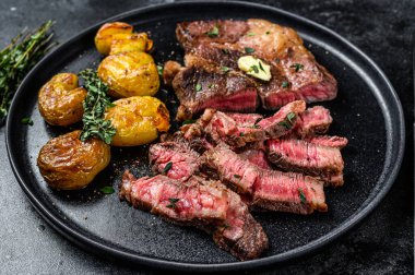 Izgara kaburga bifteği ve patates. Siyah arka plan. Üst görünüm.