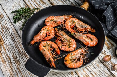 Tavada baharatlı ve limonlu ızgara karides. Beyaz ahşap arka plan. Üst görünüm.