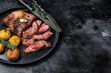Izgara kaburga bifteği ve patates. Siyah arka plan. Üst Manzara. Boşluğu kopyala.