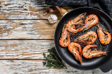 Tavada baharatlı ve limonlu ızgara karides. Beyaz ahşap arka plan. Üst Manzara. Boşluğu kopyala.