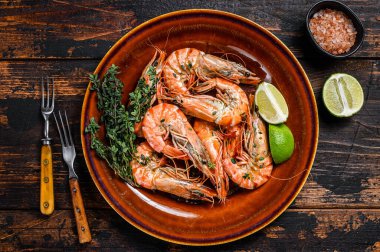 Tabakta kızarmış dev kaplan karidesleri. Koyu ahşap arka plan. Üst görünüm.