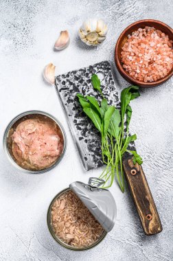 Konserve ton balığı konservesi, bütün ve doğranmış. Gri ahşap arka plan. Üst görünüm.