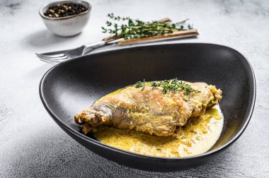 Biberiye ve sarımsaklı haşlanmış tavşan bacağı. Gri arka plan. Üst görünüm.