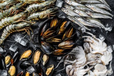 Çeşitli taze deniz ürünleri kaplan karidesleri, karidesler, mavi midyeler, ahtapotlar, sardalyalar, kokulu. Siyah arka plan. Üst görünüm.