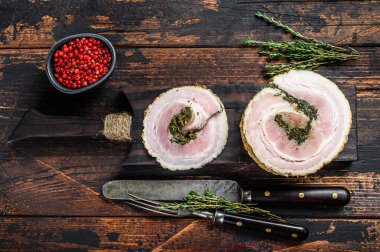 Kesme tahtasında dilimlenmiş İtalyan pancetta. Karanlık ahşap arka plan. Üst görünüm.