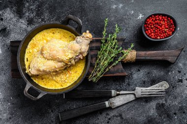 Pan 'da pişmiş tavşanlar ve sebzeler. Siyah arka plan. Üst görünüm.