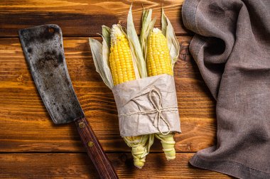 Çiftçi pazarında taze mısır koçanı, yerel sebzeler. Ahşap arka plan. Üst görünüm.