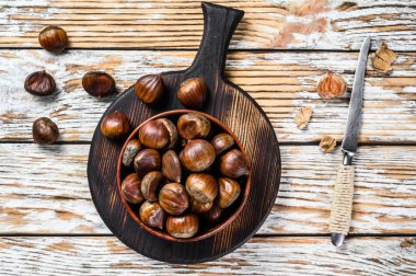 Tahta bir masada kestane ile kase. Beyaz arka plan. Üst görünüm.