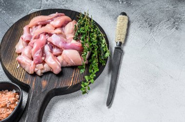 Tahta kesme tahtasının üzerinde dilimlenmiş çiğ tavuk göğsü filetosu. Beyaz arka plan. Üst Manzara. Boşluğu kopyala.