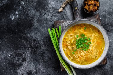 Masada erişteli taze ev yapımı tavuk çorbası. Siyah arka plan. Üst Manzara. Boşluğu kopyala.