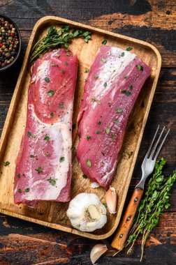 Terbiye edilmiş domuz filetosu ve kekik bifteği. Koyu ahşap arka plan. Üst görünüm.