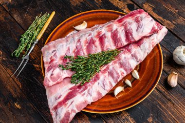 Çiğ domuz filetosu ve kekik. Koyu ahşap arka plan. Üst görünüm.