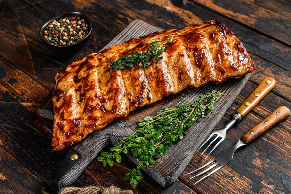 Kesme tahtasında ızgara domuz pirzolası. Ahşap arka plan. Üst görünüm.