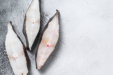 Taş masada çiğ taze balık halibut. Beyaz arka plan. Üst Manzara. Boşluğu kopyala.
