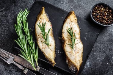 Biberiyeli balık bifteği. Siyah arka plan. Üst görünüm.