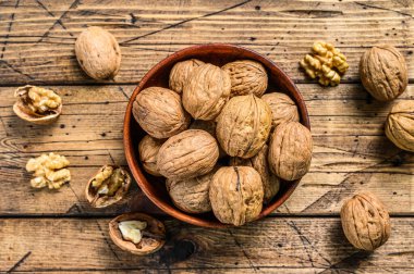 Tahta tabakta ceviz ve ceviz çekirdeği. Gri arka plan. Üst görünüm.