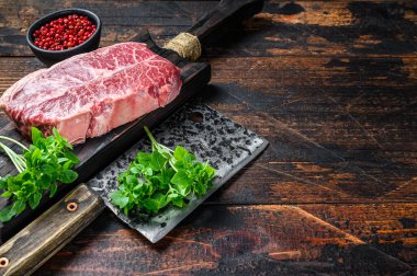 Çiğ Top Blade bifteği. Koyu ahşap arka plan. Üst Manzara. Boşluğu kopyala.