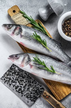 Kesme tahtasındaki çiğ deniz kabuğu balığı, baharatlar, otlar. Beyaz arka plan. Üst görünüm.