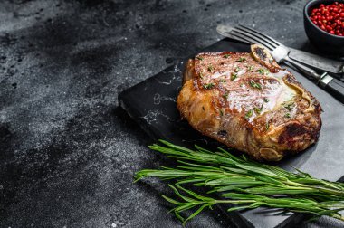 Kemiğe ızgara biftek ya da New York bifteği. Siyah arka plan. Üst Manzara. Boşluğu kopyala.