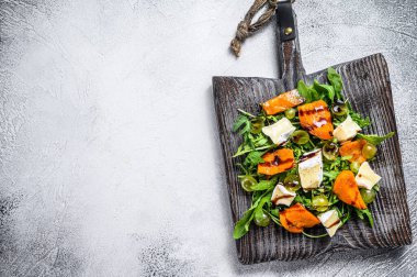 Fırında kabak ve peynirli sonbahar salatası. Sağlıklı vejetaryen gıda konsepti. Beyaz arka plan. Üst Manzara. Boşluğu kopyala.