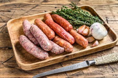 Çiğ sosis varyasyonu, sığır eti ve domuz eti. Ahşap arka plan. Üst görünüm.
