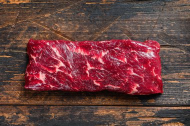 Çiğ pala ya da biftek. Koyu ahşap arka plan. Üst görünüm.