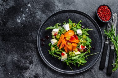 Fırında kabak ve peynirli sonbahar salatası. Sağlıklı vejetaryen gıda konsepti. Siyah arka plan. Üst Manzara. Boşluğu kopyala.