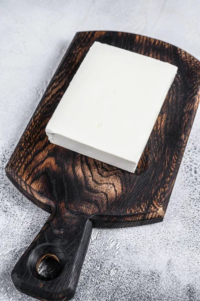 Kesme tahtasındaki Taze Paneer Cheese 'in parçaları. Beyaz arka plan. Üst görünüm.