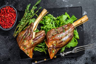 Misket tahtasında roka ile keçi güveci Shanks. Siyah arka plan. Üst görünüm.