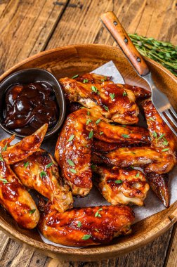 Kızarmış tavuk kanadı ve bbq sosu. Ahşap arka plan. Üst görünüm.