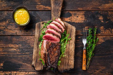 Dilimlenmiş ördek eti göğüs bifteği. Koyu ahşap arka plan. Üst görünüm.