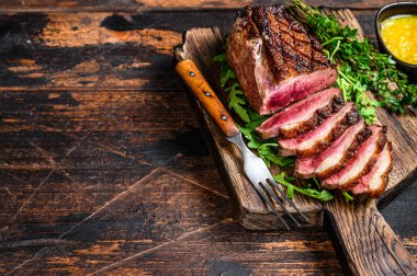 Dilimlenmiş ördek eti göğüs bifteği. Koyu ahşap arka plan. Üst Manzara. Boşluğu kopyala.