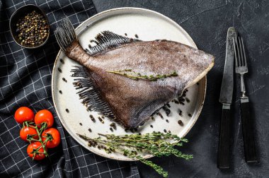 Pembe biber ve kekik ile John Dory balığı. Siyah arka plan. Üst görünüm.