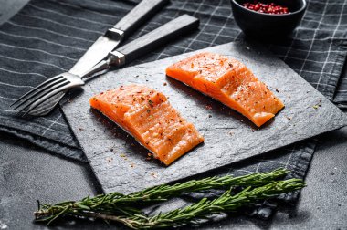 Taş bir tahtada alabalık bifteği filetosu. Siyah arka plan. Üst görünüm