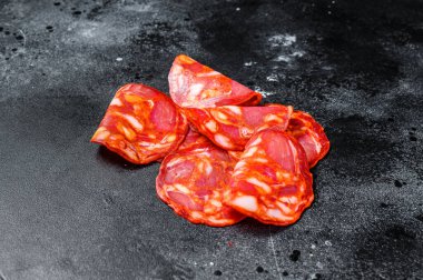 Dilimlenmiş sucuklu salam. İspanyol geleneksel sucuk sosisi. Siyah arka plan. Üst görünüm.